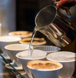 Close-up of hand pouring coffee in cup