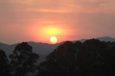 Scenic view of silhouette mountains against romantic sky at sunset