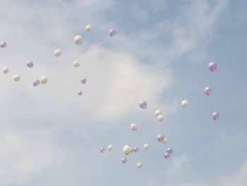 Low angle view of balloons flying against sky