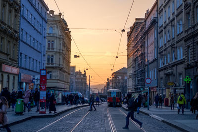 People walking on road along buildings