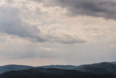 Scenic view of mountains against cloudy sky