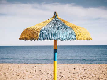 Umbrella on beach against sky