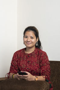 Portrait of smiling young woman using mobile phone