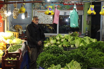 Young woman with vegetables for sale at market stall