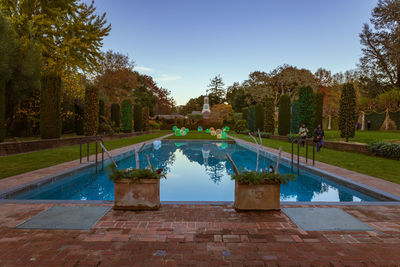 View of swimming pool in park against clear blue sky