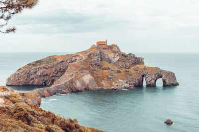 Rock formations by sea against sky