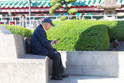 Side view of a man sitting outdoors