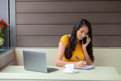 Young woman using laptop at table