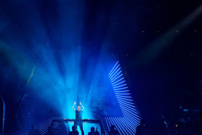 Low angle view of illuminated lighting equipment at night