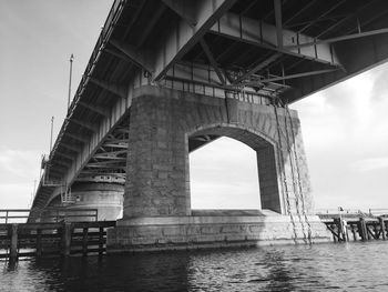 Low angle view of bridge against cloudy sky