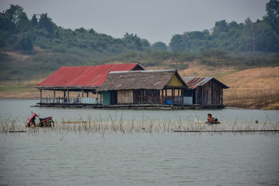 People in lake by houses