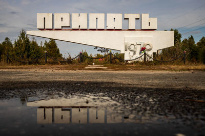 Text on road against sky in city