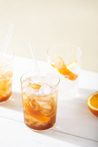 Cold brew coffee mocktail with orange peel. glass with citrus tonic with ice on white background