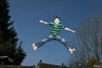 Boy jumping on trampoline in woking - england