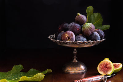 Close-up of figs on table against black background