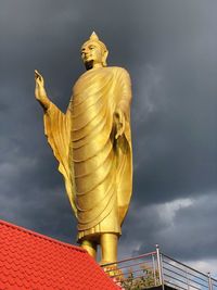 Low angle view of statue against building against sky