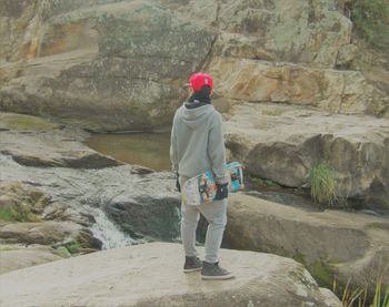 Rear view of man standing on rock