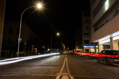 Illuminated light trails on road in city at night