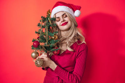 Young woman wearing mask against red background