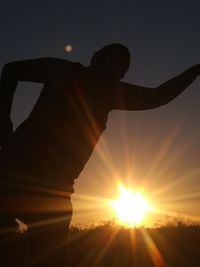 Silhouette man against sun during sunset