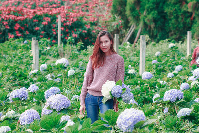 Portrait of smiling young woman in flower pot