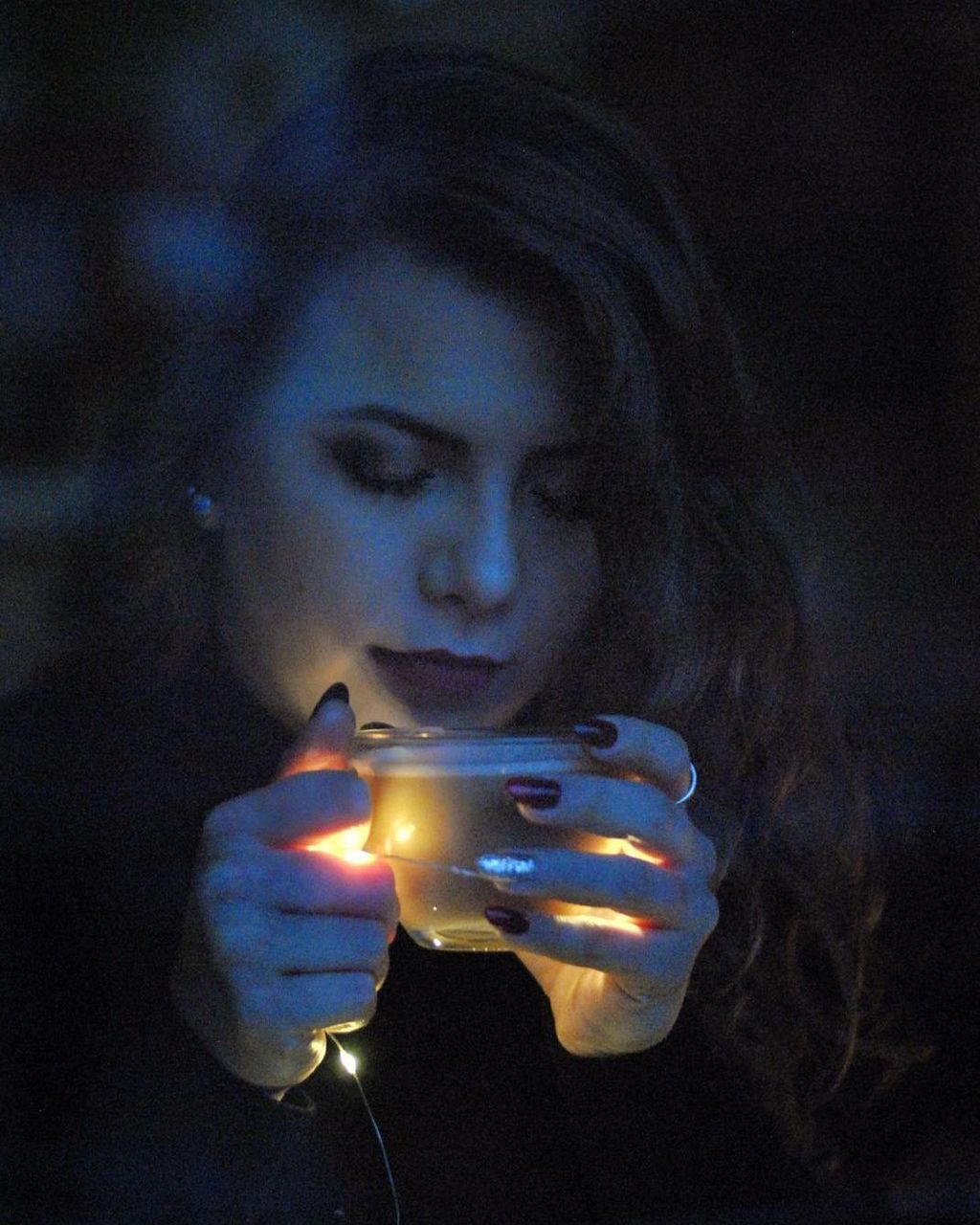 flame, burning, glowing, heat - temperature, holding, one person, close-up, illuminated, lighting equipment, real people, young adult, night, focus on foreground, young women, indoors, black background, one young woman only, people