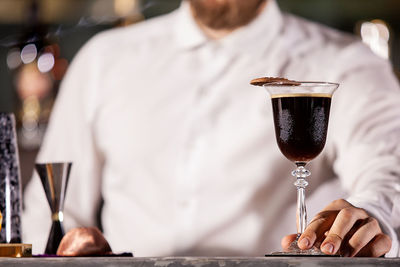 Midsection of man holding wineglass