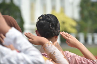 Rear view of woman saluting