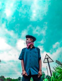 Low angle view of young man looking against sky