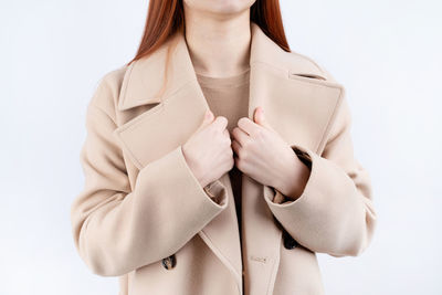 Midsection of woman with arms crossed against white background