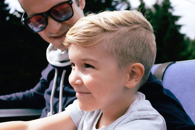 Close-up of happy kid ride enjoying in ropeway ride wit his father in the mountains.