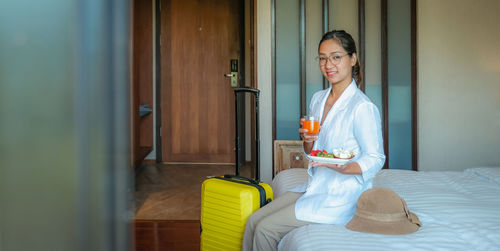 Woman holding a while sitting by door