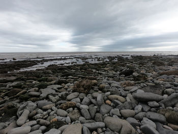 Rocks on beach against sky