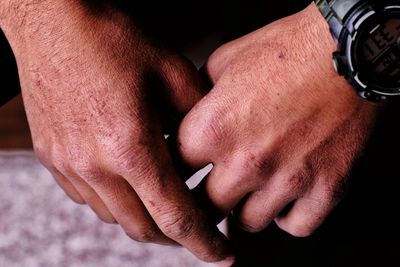 Cropped hands of man wearing wristwatch