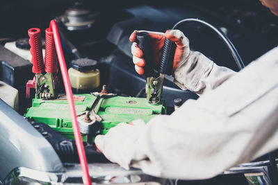 Mechanic repairing car engine in garage