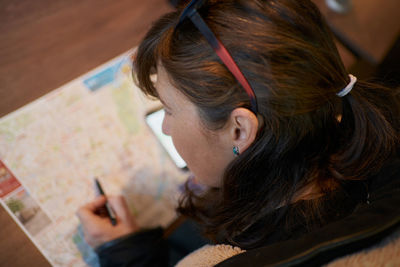 Woman tourist studies map of a city sitting person