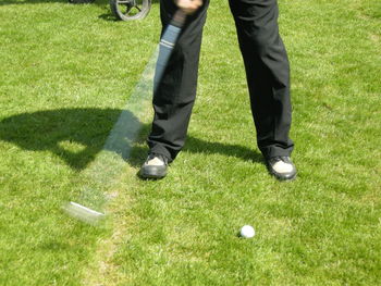 Low section of man playing golf on course