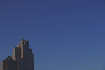 Low angle view of modern building against blue sky