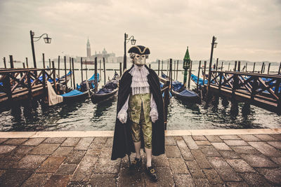 Man standing on wooden post in canal