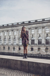 Full length of woman standing against building in city