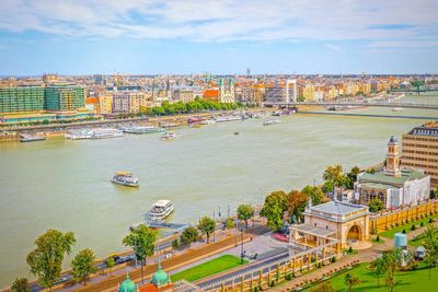 High angle view of buildings by river against sky