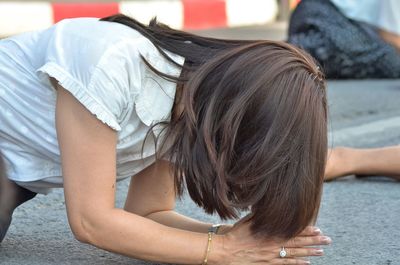 Woman praying on street during performance