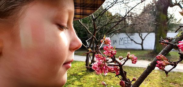 Close-up portrait of woman against red flowering plants