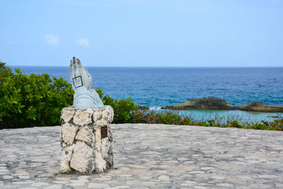 Statue by sea against clear sky