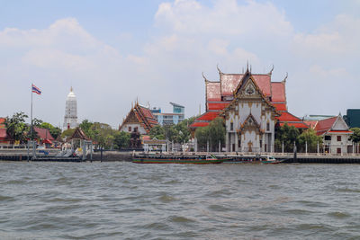 River amidst buildings in city against sky