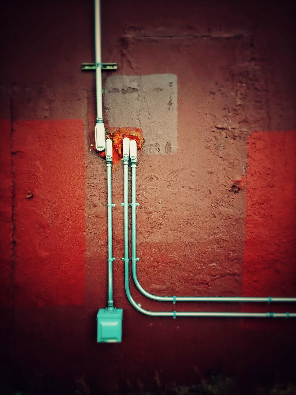 CLOSE-UP OF RED PIPE ON WALL