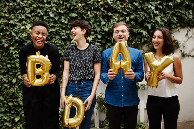 Friends holding balloons during birthday celebration