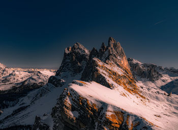 Scenic view of snowcapped mountains against clear blue sky