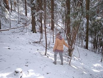 Rear view of person standing on snow covered land