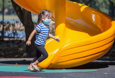 Low angle view of boy playing on slide at playground